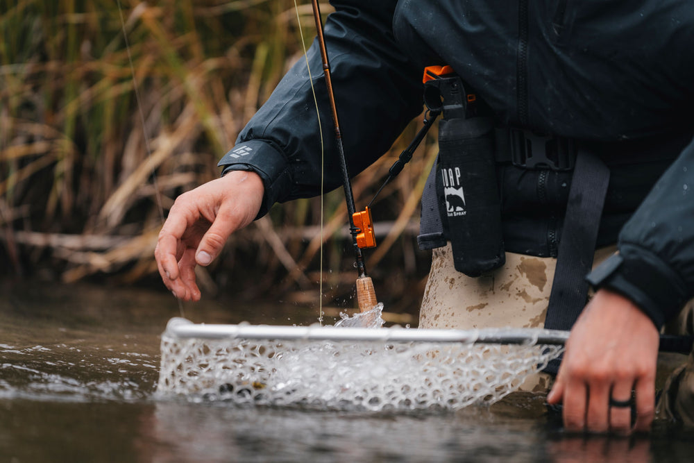 Angler with the docking station on his waders and rod docked